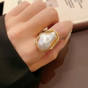 Close-up of a French vintage baroque faux pearl ring featuring a gold textured frame