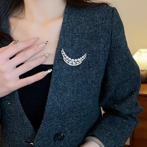 Détail d'une élégante broche en perles et zircons sur un blazer en tweed gris chic