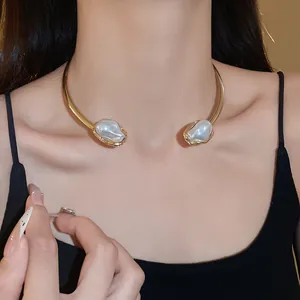 Detailed close-up of a vintage gold open choker with two irregular baroque faux pearls