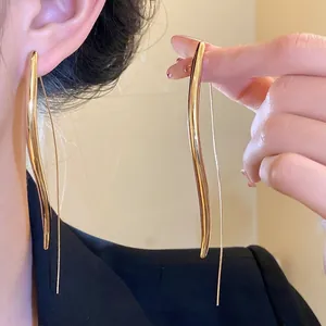 Elegant long wavy gold earrings with sleek metallic finish for a minimalist chic look