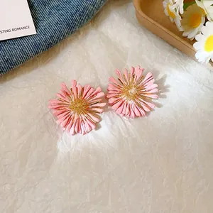Close-up of pink flower cluster stud earrings with detailed petal texture.