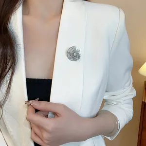 Vue détaillée d'une élégante broche lune et flocon d'argent sur un blazer blanc