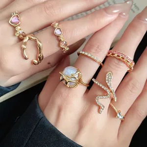 Vintage gold ring set with heart stones, baroque pearl, and snake design on hand