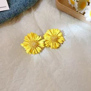 Detailed close-up view of yellow daisy flower stud earrings with delicate petal textures