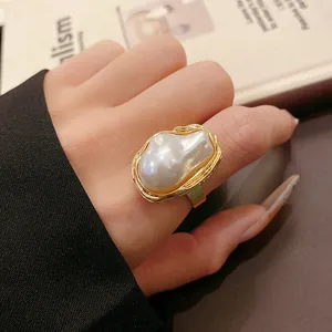 Detailed view of a vintage irregular baroque pearl ring with gold pleated frame
