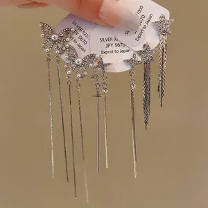 Close-up of elegant butterfly and star tassel earrings with rhinestones and pearls