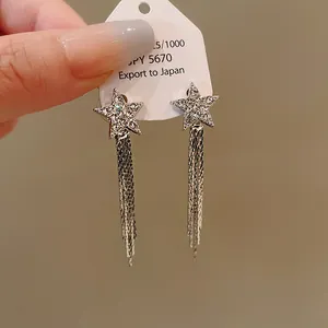 Detailed view of sparkling star stud earrings with elegant long silver chain tassels