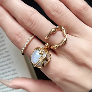 Detailed macro view of vintage gold ring set with rhinestones and white pearl on hand
