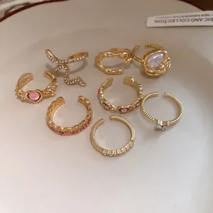 Macro view of vintage gold-plated open ring set with heart and rhinestone accents