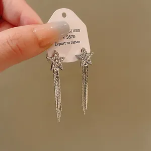 Detailed view of elegant star-shaped rhinestone earrings with long silver tassel chains