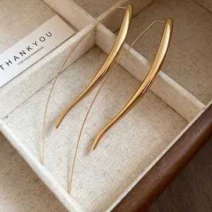 Elegant smooth gold-finished long drop hook earrings displayed in a jewelry box tray.