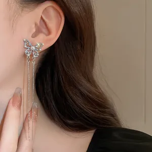 Close-up detail of elegant silver butterfly tassel earrings with pearls and diamonds