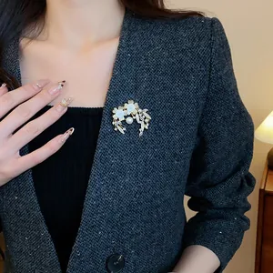 Élégante broche fleur et perle plaquée or avec zircons épinglée sur le revers d'un blazer