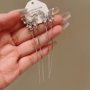 Detailed close-up of elegant pearl butterfly tassel earrings decorated with sparkling rhinestones