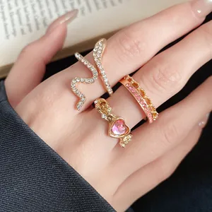 Close-up of vintage French style heart and snake rhinestone ring set worn on hand