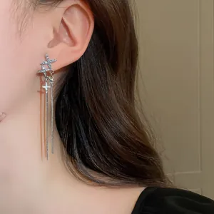 Elegant silver star tassel earrings with sparkling stones shown as a close-up detail.