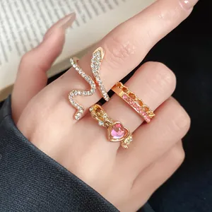 Close-up detail of vintage ring set with pink heart gem and crystal snake design