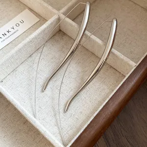 Detailed view of sleek silver-tone drop hook earrings with minimalist curved design