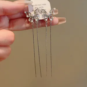 Detail of butterfly tassel earrings with pearls and rhinestones on a silver needle