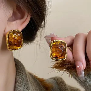 Detailed macro view of vintage brown resin earrings with twisted gold frame detail.