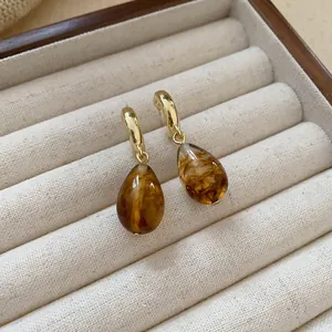 Detailed macro shot of vintage brown marbled resin teardrop earrings in a jewelry case