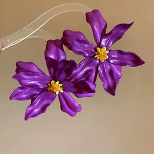 Detailed macro view of purple acrylic flower earrings with yellow beaded centers.