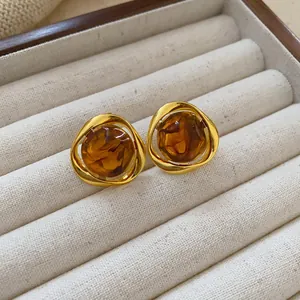 Detailed view of vintage geometric stud earrings with golden frames and amber-colored resin centers