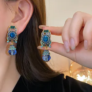 Close-up of vintage geometric earrings with blue crystals and gold-tone plating