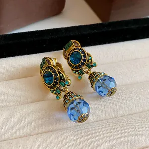 Detailed macro view of vintage blue crystal geometric drop earrings in jewelry box