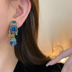 Macro detail of vintage crystal drop earring featuring vibrant blue and green rhinestones
