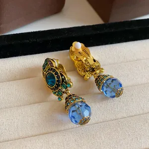 Detailed macro view of vintage blue crystal drop clip-on earrings with gold finish