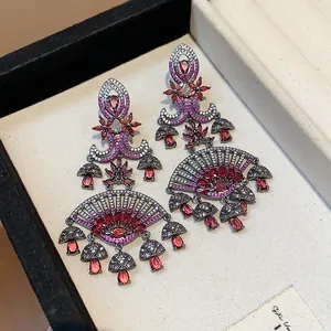 Detail view of luxury vintage fan-shaped earrings featuring pink and red zircon stones.