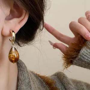 Detailed close-up shot of elegant retro Maillard style coffee teardrop earrings worn on model ear