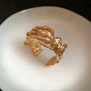 Detailed view of an irregular gold crumpled metallic cuff bracelet with unique lava texture
