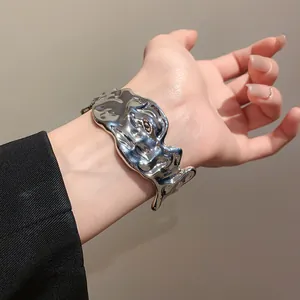 Close-up of irregular molten silver cuff bracelet with wrinkled metallic texture