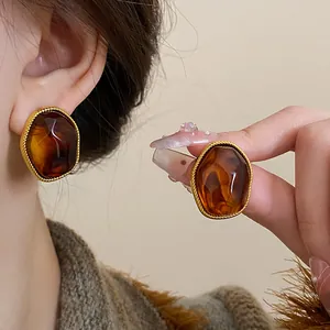 Detailed shot of vintage amber-colored geometric earrings with gold-tone braided edges