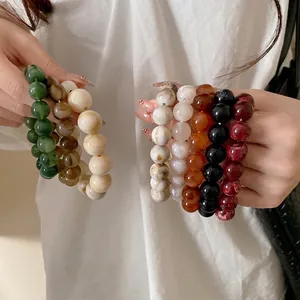 Vintage marble pattern beaded bracelets in multiple colors held by a model