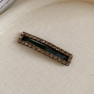 Detail of square hair clip with brown rhinestones and elegant sparkling finish.