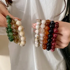 Close-up of marbled beaded bracelets in various colors with elegant ink-wash patterns