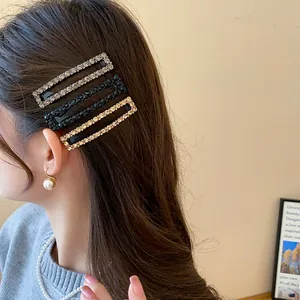 Close-up detail shot of elegant sparkling rectangular rhinestone hair clips worn by a model.