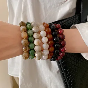 Detailed close-up of colorful ink-wash beaded bracelets worn on a wrist.
