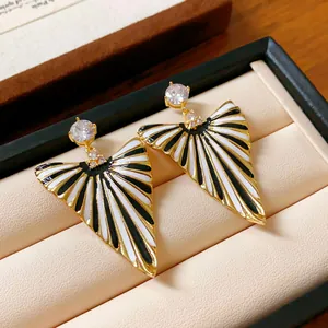 Gros plan détaillé de boucles d'oreilles triangulaires rayées avec zircon dans boîte