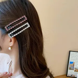 Close-up view of elegant square rhinestone hair clips worn on the model's dark hair