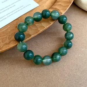Detailed close-up of a green tie-dye beaded bracelet resting on a rustic wooden tray
