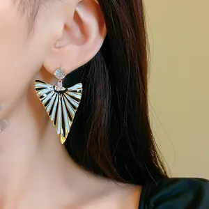 Gros plan détaillé de boucles d'oreilles triangulaires à rayures vintage avec zircons