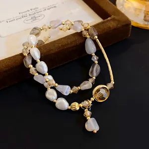 Primer plano de una pulsera multicapa de lujo con perlas y detalles dorados