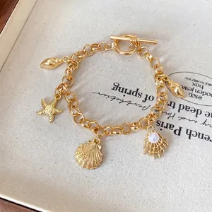 Bracelet à breloques doré avec pendentifs étoile de mer et coquillage sur chaîne