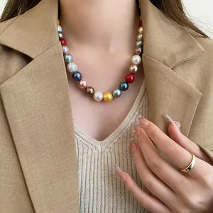 Detailed view of colorful dopamine pearl choker necklace on model in khaki blazer