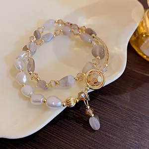 Vista detallada de una pulsera elegante de dos capas con perlas y ágatas grises