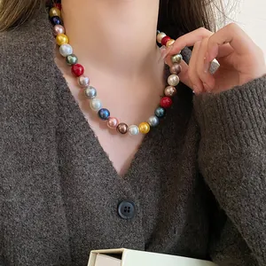 Close-up detail of a colorful dopamine style round pearl beaded necklace on model